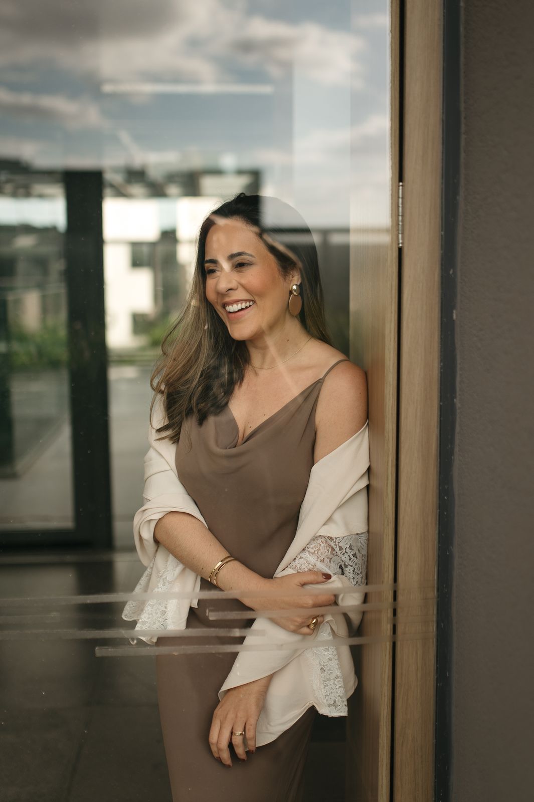 Luíza Sales sorrindo, encostada na janela