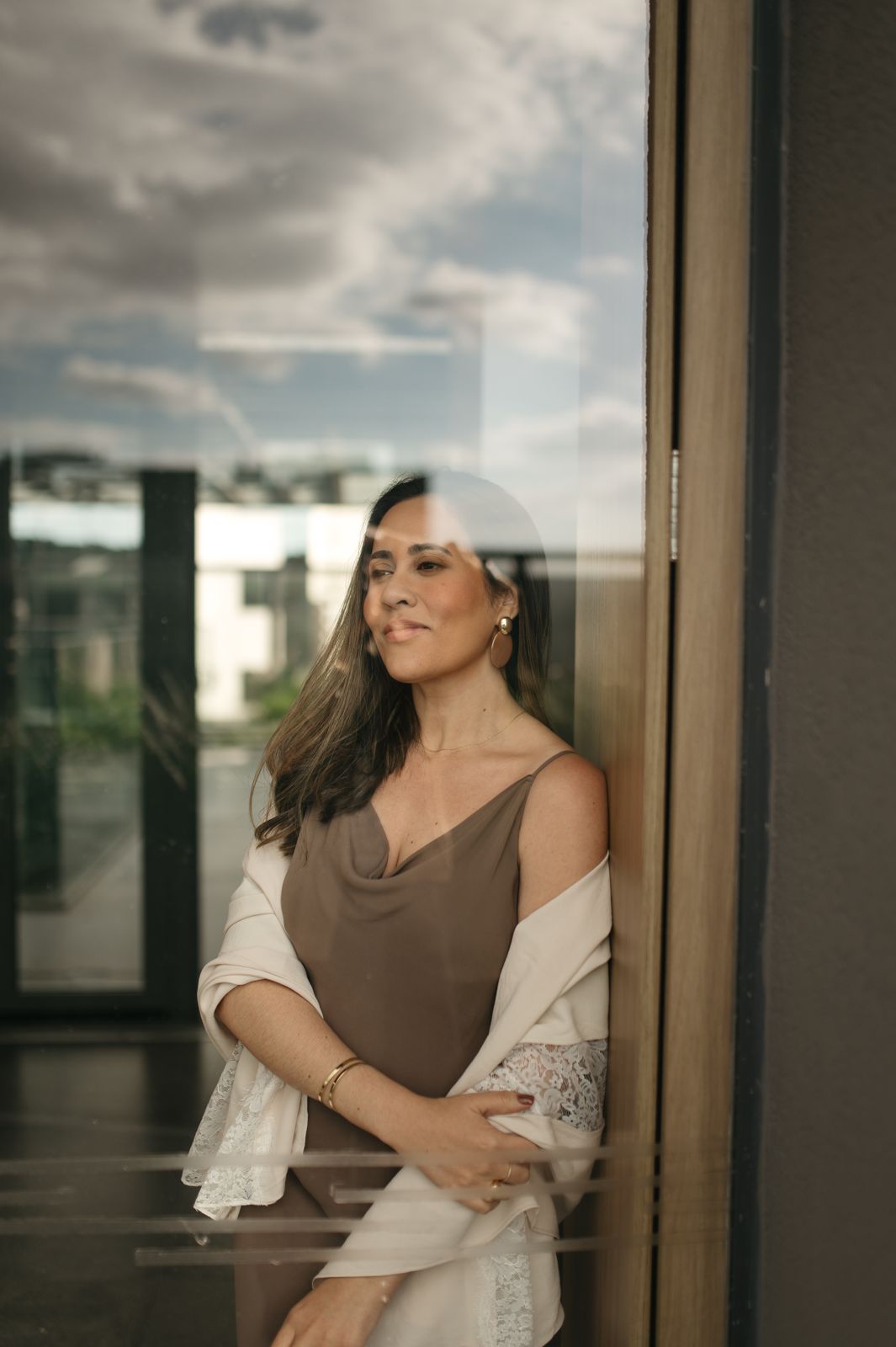 Luíza Sales sorrindo, encostada na janela
